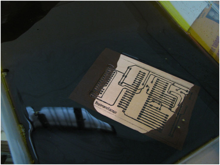 Image showing PCB dipped in a solution of ferric chloride for etching Image showing PCB dipped in a solution of ferric chloride for etching
