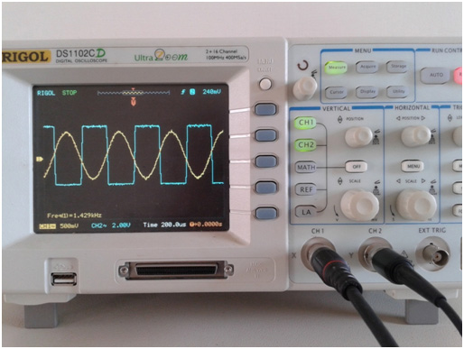 Image showing Input and Output Waveforms of LM741 IC based Sine Wave to Square Wave Converter on Display Panel of an Oscilloscop