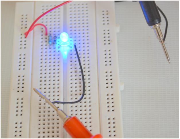 Image showing multimeter probes connected to LED circuit for measuring current