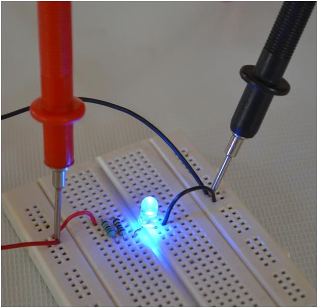 Image showing multimeter probes connected to LED circuit for voltage testing